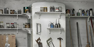 Old refridgerator in a garage being used for storage