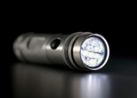 Silver flashlight with a dark background Silver flashlight with a dark background