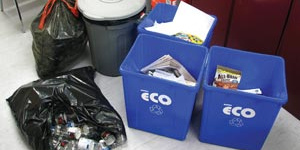 Recycling bins and a garbage bag filled with plastic bottles