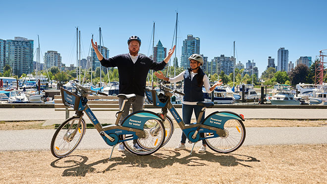 BC Hydro's spokespeople Dave and Jaclyn with Mobi e-bikes on the seawall in Vancouver's Stanley Park