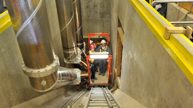 installing conductors in tunnels from the underground units of Mica. A small cart on rails was used to transport works up and down the tunnel.
