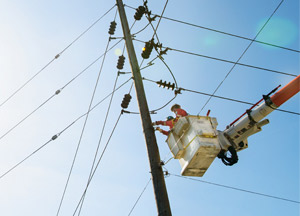 Two power line technitions in a bucket truck working on a line Two power line technitions in a bucket truck working on a line