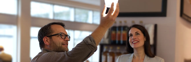 Image of two people looking up at a light bulb
