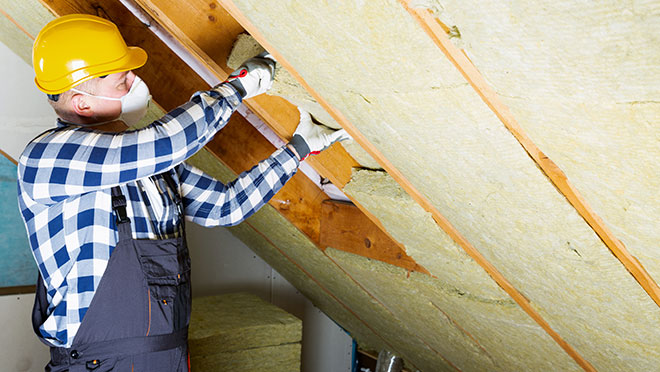 Image of a contractor installing insulation in an attic