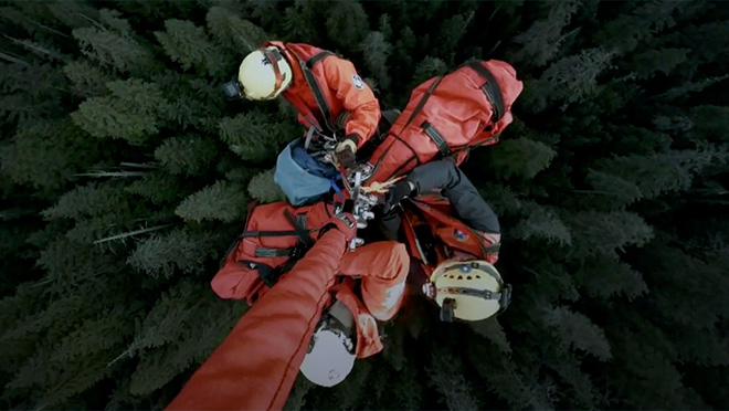Image of volunteers from North Shore Rescue hanging from a helicopter