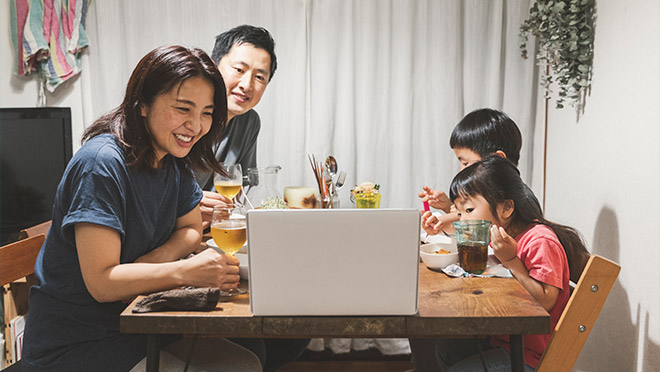 Image of a family eating dinner and meeting remotely