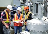 Three industrial workers in a plant Three industrial workers in a plant