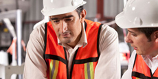 Two men in vests and hardhats