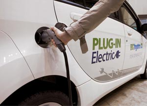 Person plugging in an electric vehicle to charge