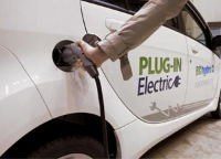 Person plugging in an electric vehicle to charge Person plugging in an electric vehicle to charge