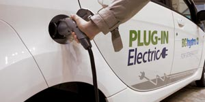 Person plugging in an electric vehicle to charge