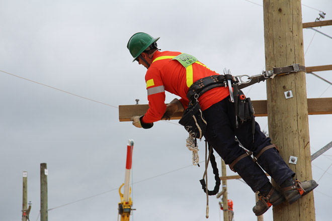 Power line technicians in Safety Rodeo on power pole