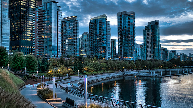 Skyscrapers of Vancouver at dusk, looking west beside a Coal Harbour walking path near the Jack Poole Plaza