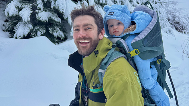 Ryan Gregory from Market Transformation hikes in the snow with his infant son, Bear, strapped to his back