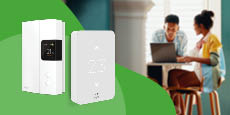 An installed smart thermostat in the foreground with family relaxing in the background. An installed smart thermostat in the foreground with family relaxing in the background.