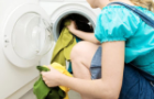 Woman using a front loading washing machine Woman using a front loading washing machine