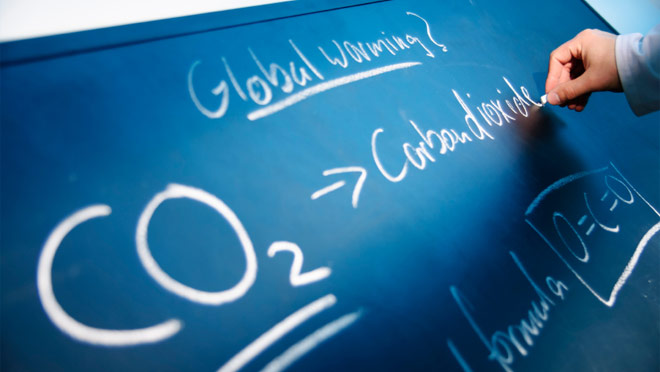 Image of carbon emissions message written on chalkboard Image of carbon emissions message written on chalkboard
