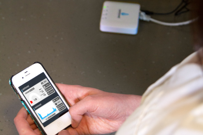 Person holding phone browsing consumption graphs Person holding phone browsing consumption graphs