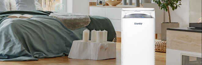 A portable air purifier in a bedroom.