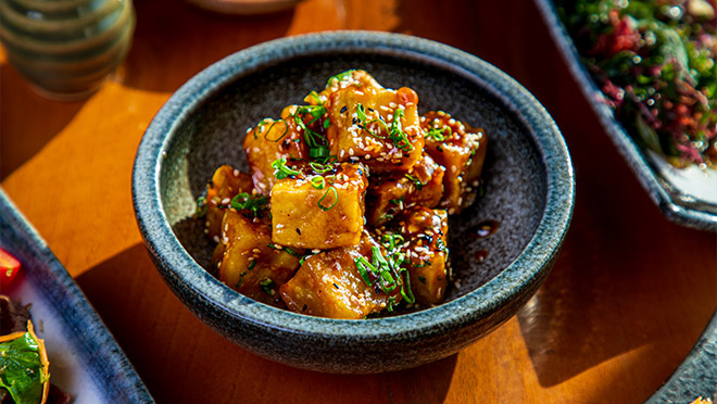 A bowl of honey garlic tofu cooked in an air fryer