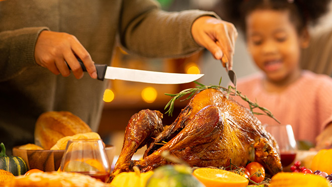 Family carving a holiday turkey