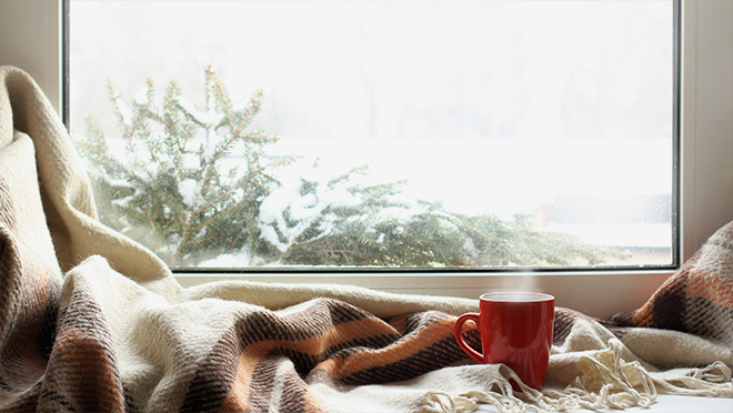 Photo by a window with a cup and blanket Photo by a window with a cup and blanket