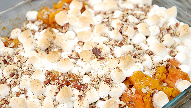 Up-close photo of a dish of sweet potato and marshmallow casserole Up-close photo of a dish of sweet potato and marshmallow casserole