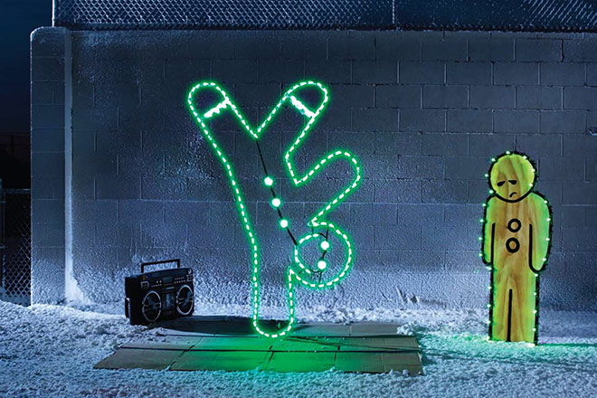 An LED gingerbreadman breakdances in a winter scene