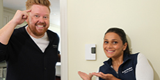 Dave and Jaclyn next to a thermostat