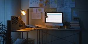 Shot of technology and paperwork on a desk in an empty home office at night