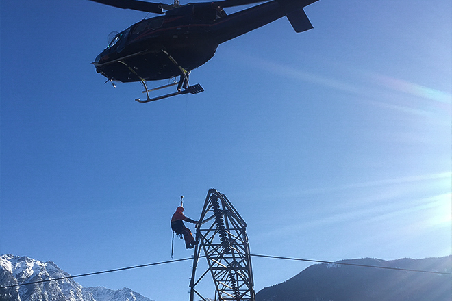 Image of a helicopter lowering a BC Hydro line crew Image of a helicopter lowering a BC Hydro line crew