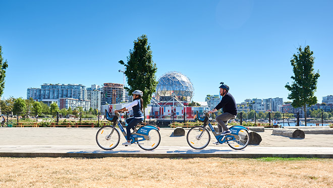 BC Hydro's spokespeople Dave and Jaclyn riding Mobi e-bikes near Vancouver's Science World