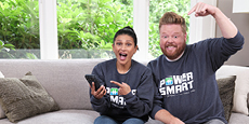 BC Hydro spokespersons, Dave raising his arms and Jaclyn pointing to her smartphone are promoting the Peak Saver program