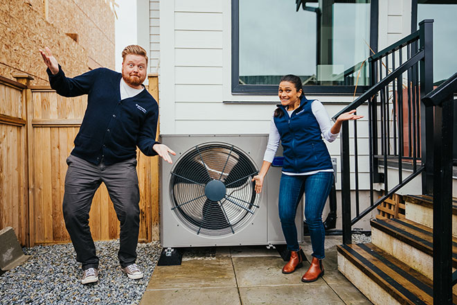 Dave and Jaclyn standing in front of a heat pump