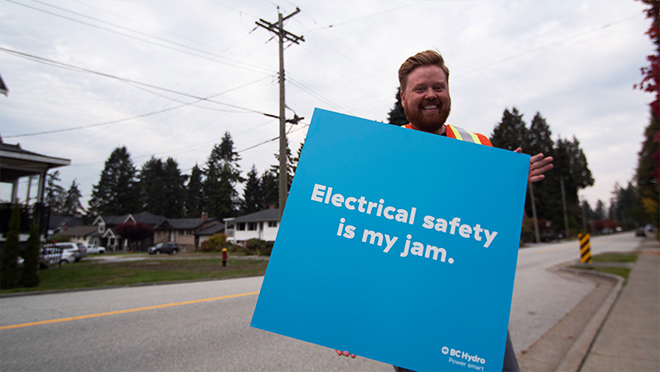 Dave with a sign by a street Dave with a sign by a street