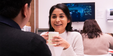 Employee with coffee chatting with colleague