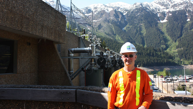 Morgan McLennan at Mica dam Mica plant manager Morgan McLennan stands atop Mica Dam with 'reactor alley' and Mt. Nagle of the Monashee range in the background.