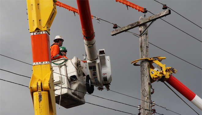 Image of workers replacing an aging power pole