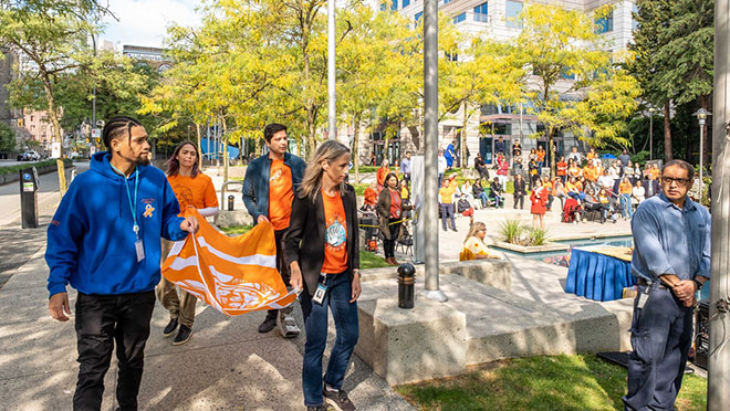 Members of BC Hydro's RAIN Network carry the Indigenous Survivors flag