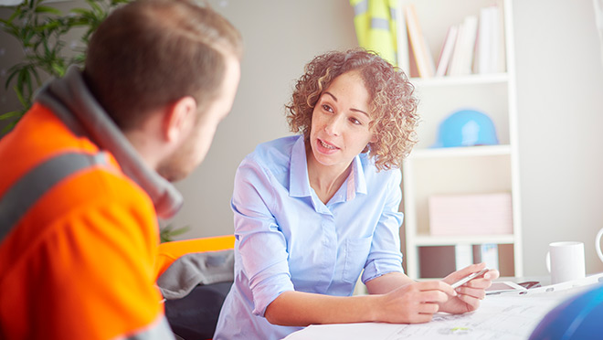 Image of an architect and site lead talking in an office