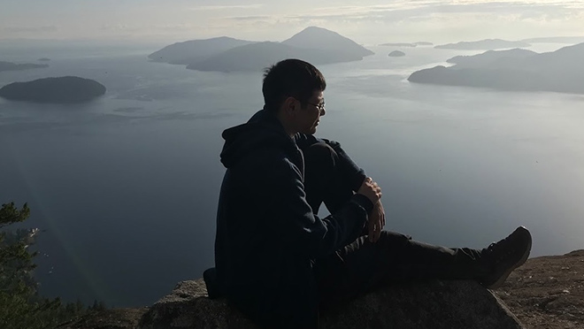 Austin Whitney is sitting atop Howe Sound Lookout.
