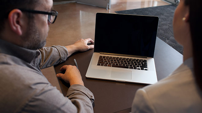 Image of contractor and client sitting in front of a laptop computer Image of contractor and client sitting in front of a laptop computer