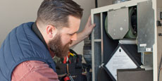 Man looking at some HVAC equipment.