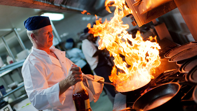 Image of a cook working in a commercial kitchen Image of a cook working in a commercial kitchen