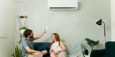 couple in apartment adjusting heat pump