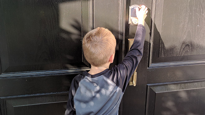 Image of young boy opening door with a Schlage Camelot Wi-fi integrated lock Image of young boy opening door with a Schlage Camelot Wi-fi integrated lock