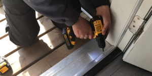 Man using power tool on door frame