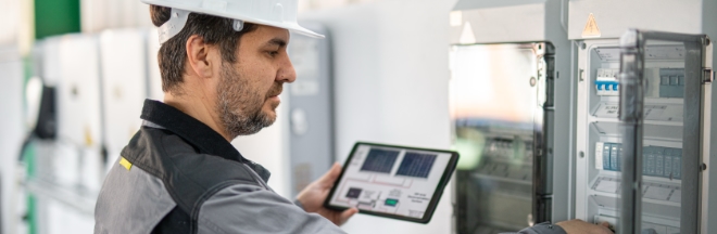 Engineer examining electric smart-grid system. Engineer examining electric smart-grid system.