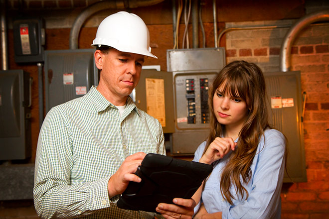 Two engineers look at a tablet computer