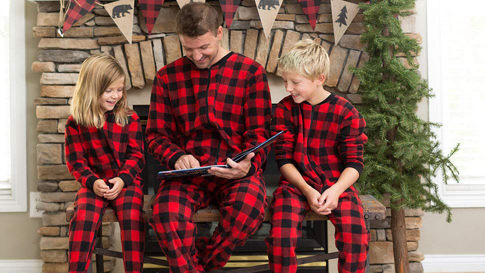A family reading a book together and wearing matching onesies A family reading a book together and wearing matching onesies